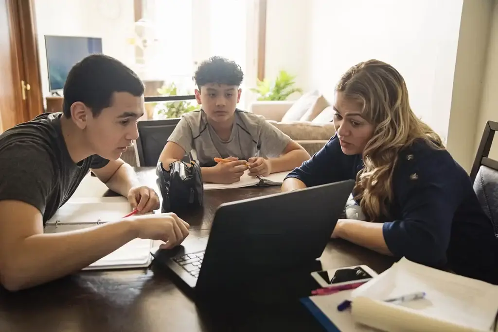 A group of teens sitting at the table doing homework