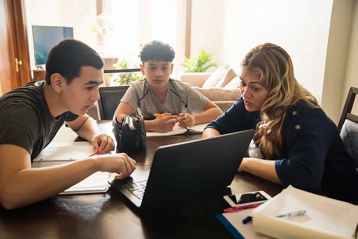 A group of teens sitting at the table doing homework